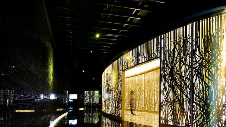 Architectural façade of the Holy See Pavilion featuring intricate golden lattice details.